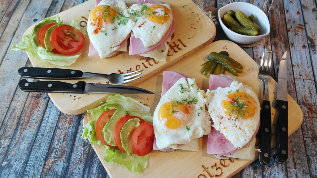 keto food on two cutting boards, fried eggs, tomato, and lettuce