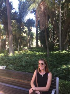 Kayla Douglas sitting on a bench in a park 