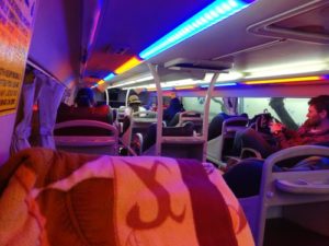 view of interior of the bus with blankets on seats 