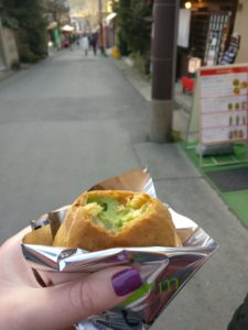 a hand holding a foil wrapped cream puff filled with green cream, a delicious part of life after keto 