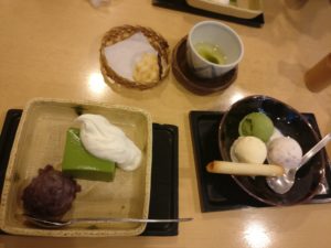 One  square plate of matcha cake with cream and bean paste, a bowl with three scoops of ice cream