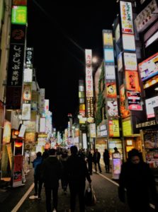 a Tokyo street lit up by hundreds of signs 