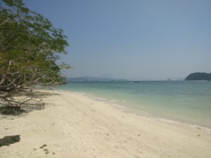white beach with pale blue water
