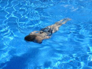 woman submerged in blue water 