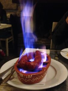 a dish with sausage and flames in a restaurant 