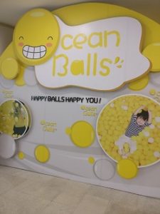 A white and yellow sign reading"Ocean Balls! Happy balls happy you!"