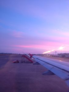 wing of an airplane on the ground at sunset