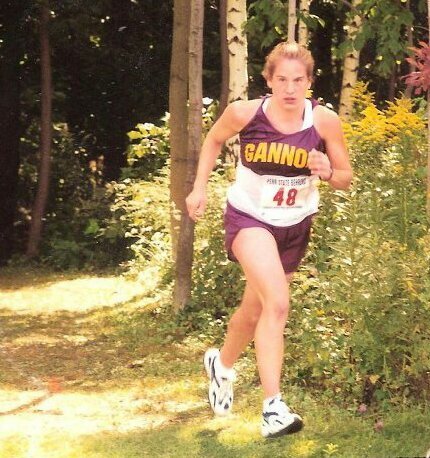 Jill Hetrick running for Gannon University in her white and burgundy uniform