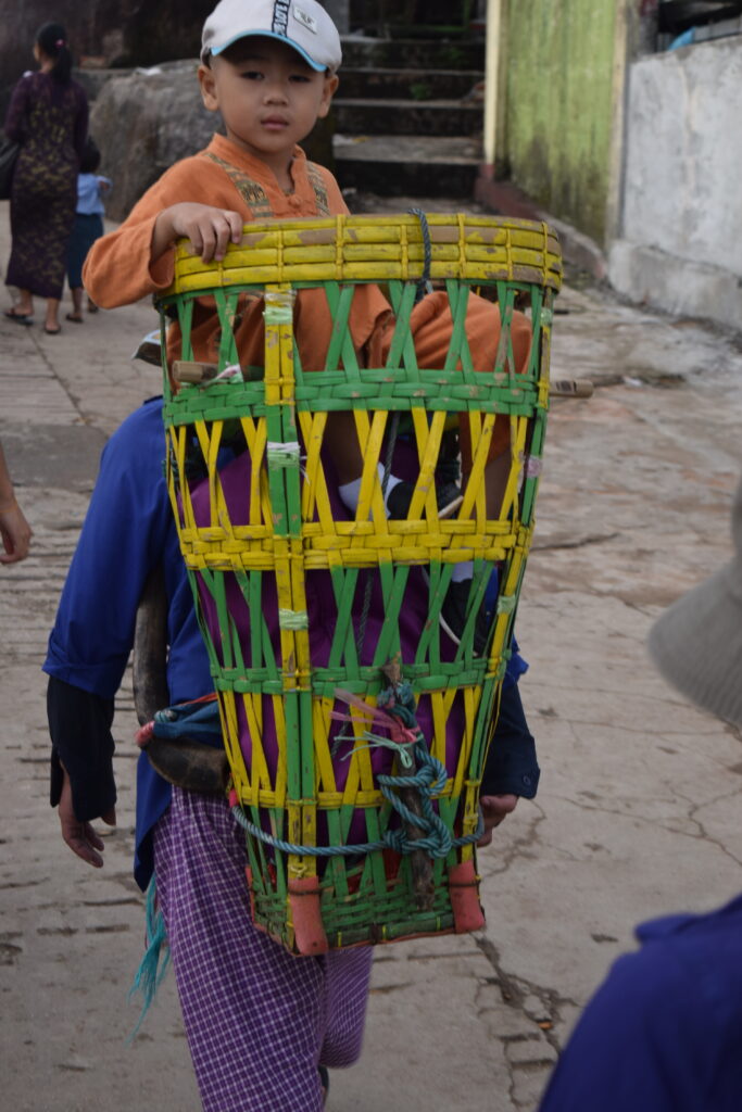 A child sits in a basket backpack going up to golden rock