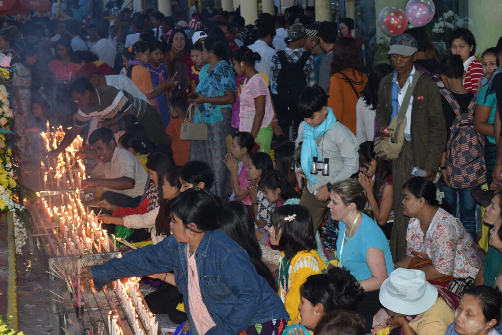 people praying and lighting candles at Golden Rock on Thadingyut 2018