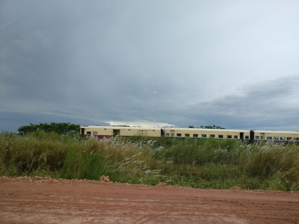 a train runs parallel to the road in Myanmar