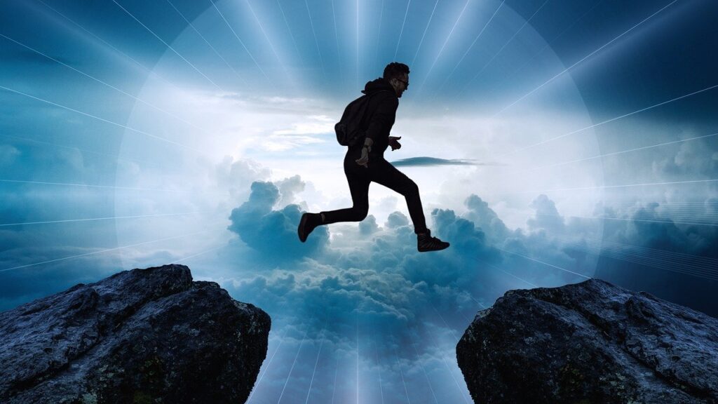 A man leaping from one rock to another with a beautiful background is like starting a new chapter 